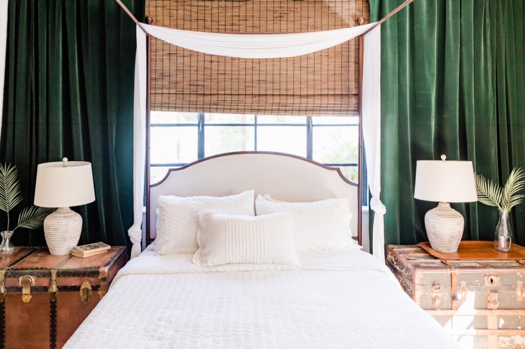 bedroom with green curtains behind the bed